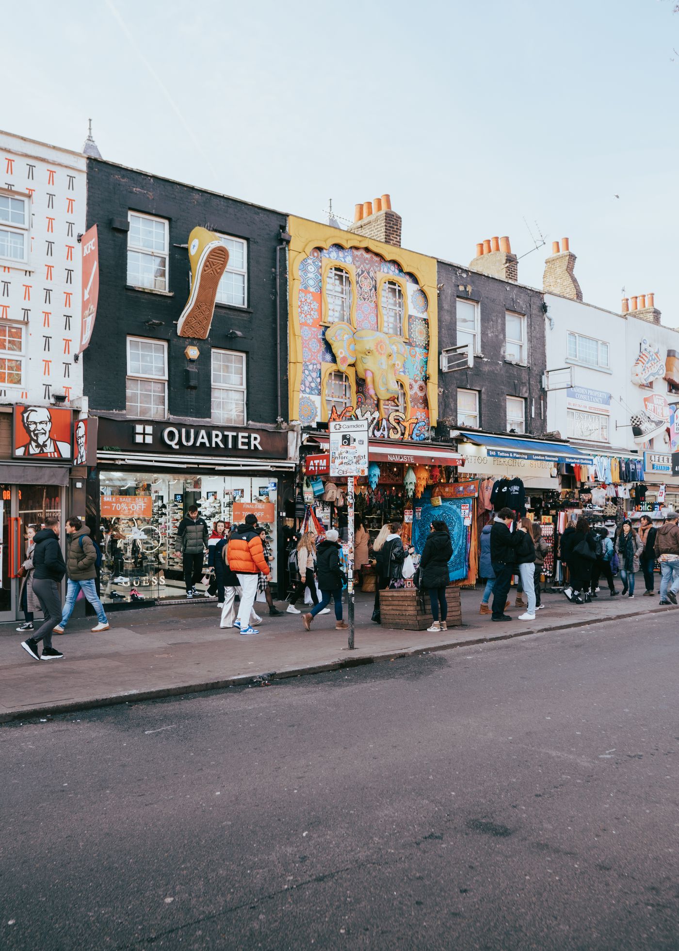 Colourful shopfronts and signs along a busy street in Camden