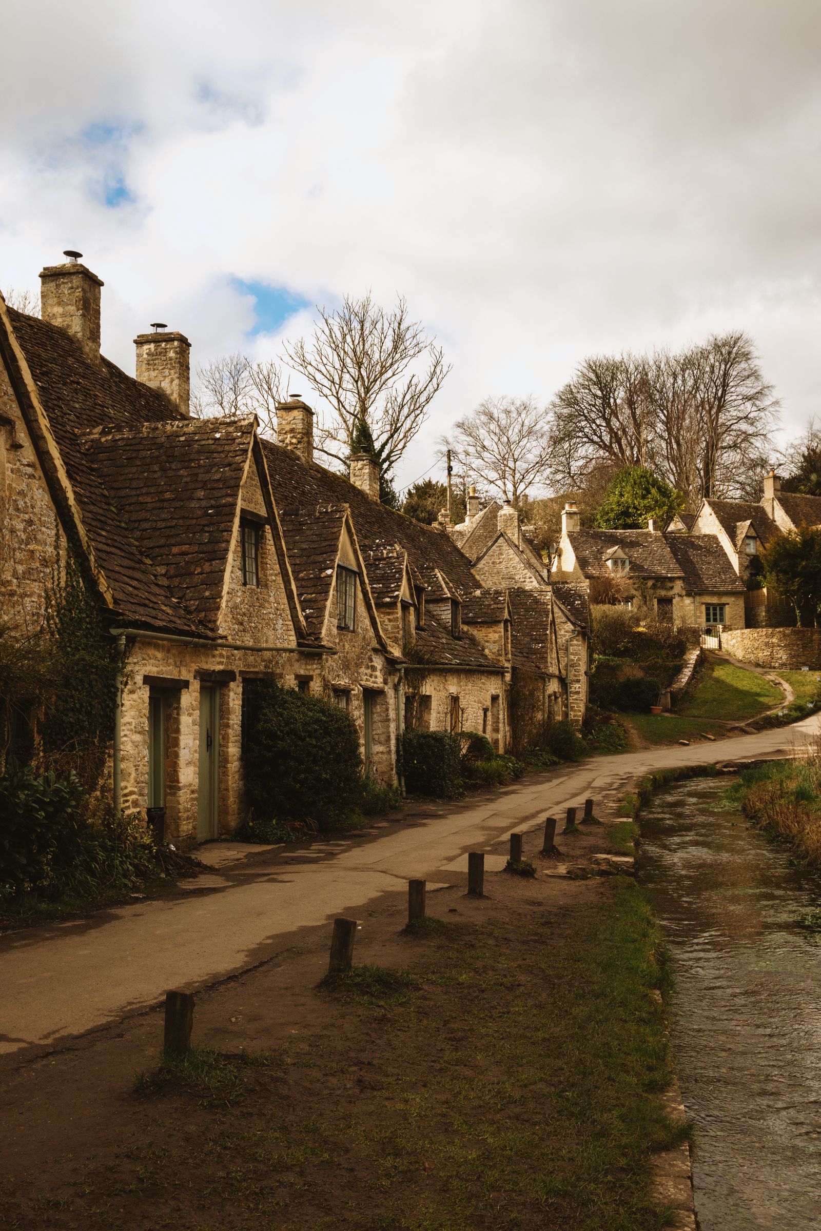 Honey-coloured stone cottages lining a quiet lane in the Cotswolds