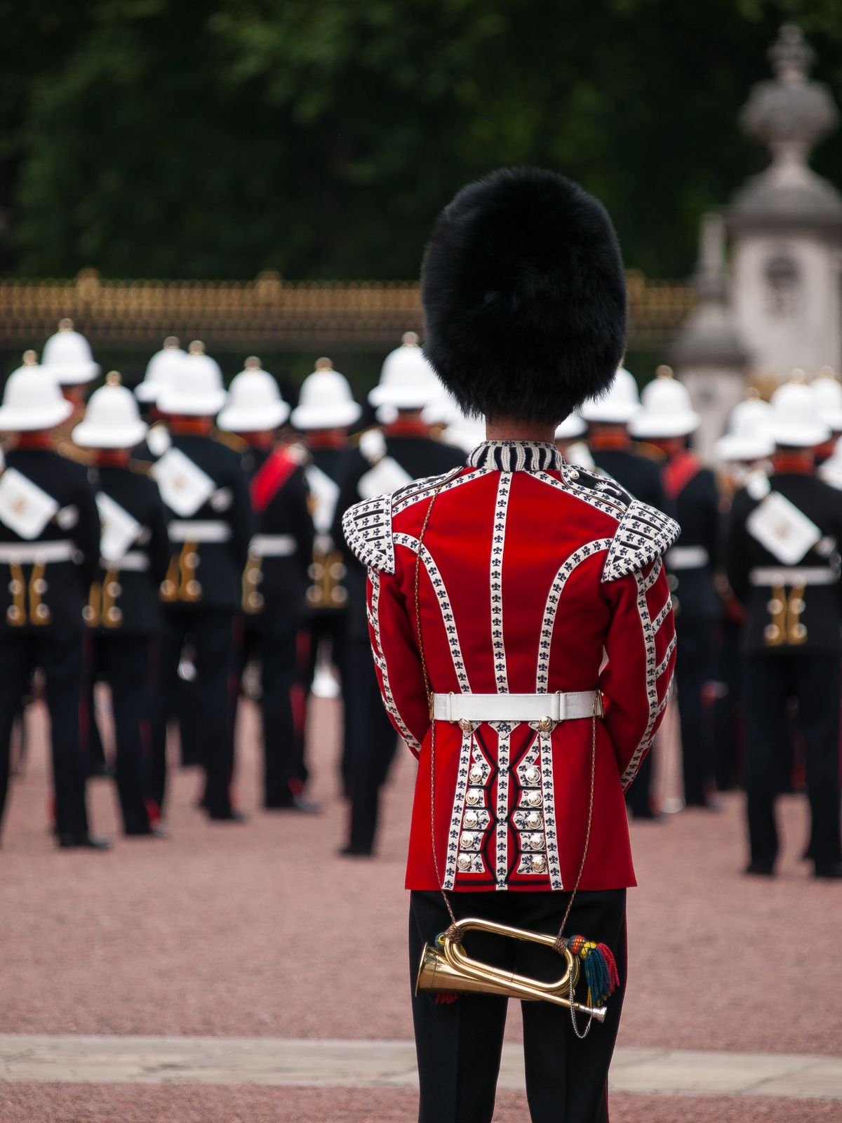 A guard in a red ceremonial uniform standing to attention