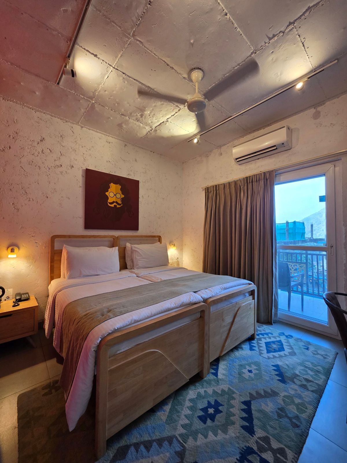 A neat twin hotel room with two beds and a bright window