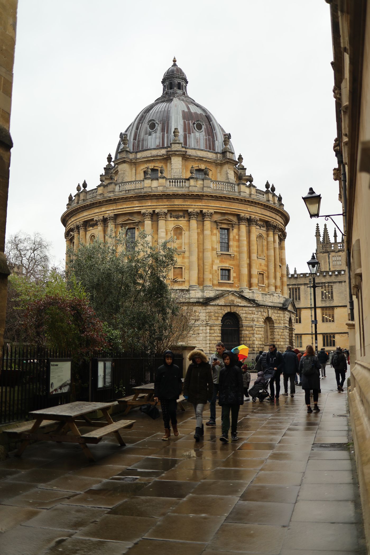 People walking past the historic buildings of the University of Oxford
