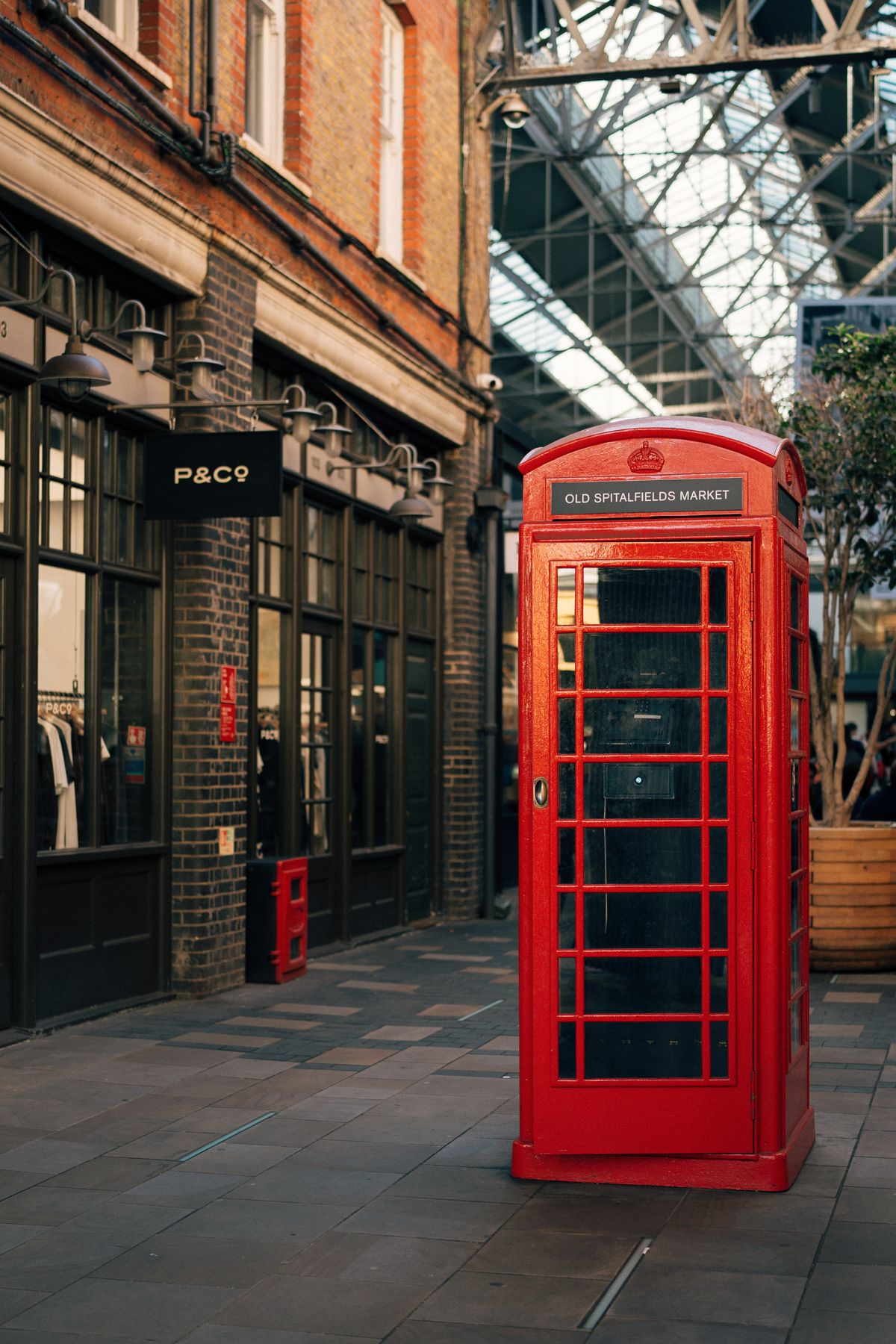 A red telephone box beside a busy market street