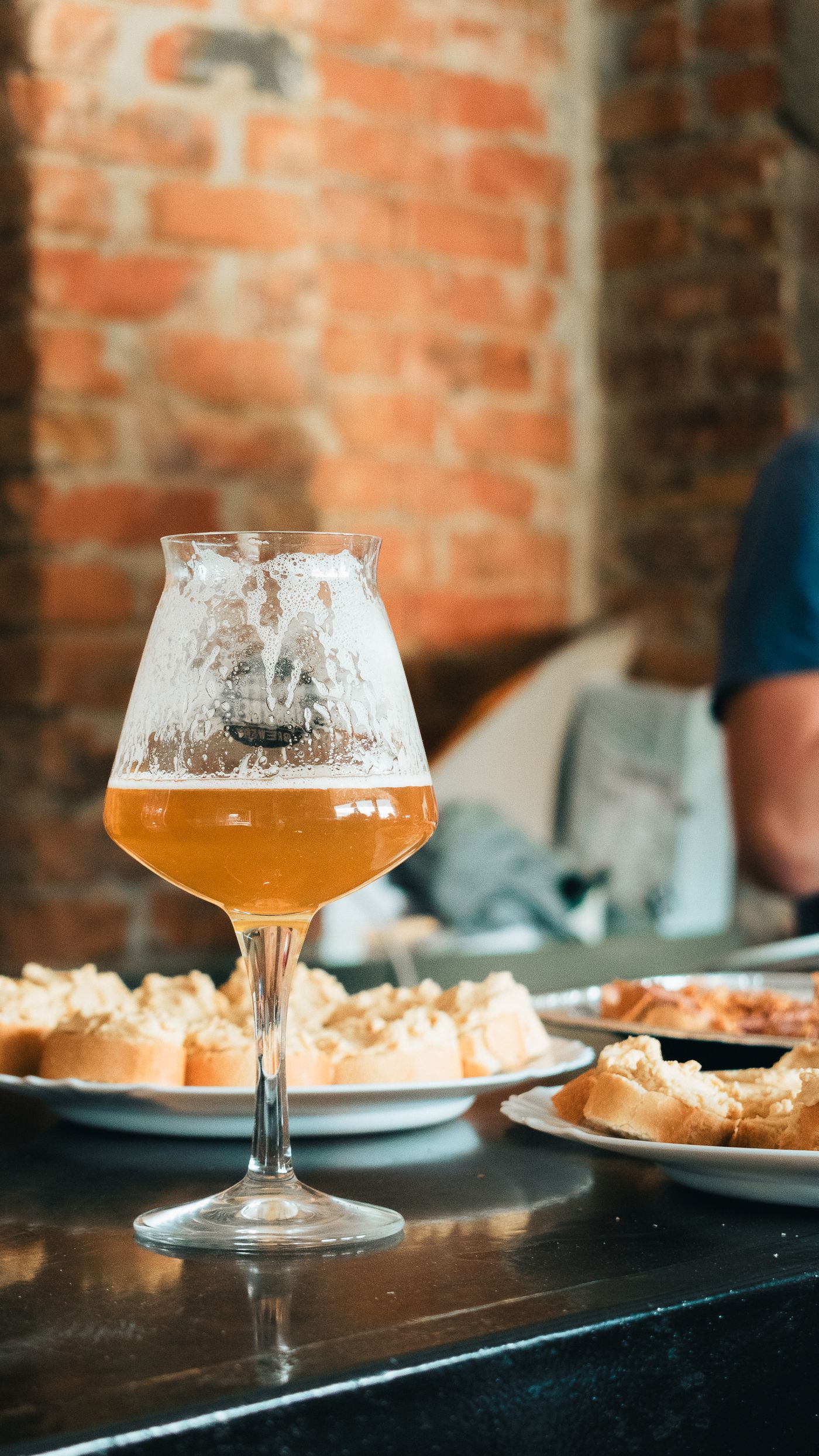 A glass of craft beer standing on a wooden pub table