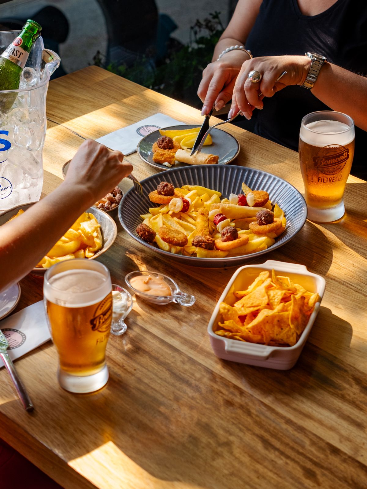 A hearty pub meal with beer and snacks on a wooden table